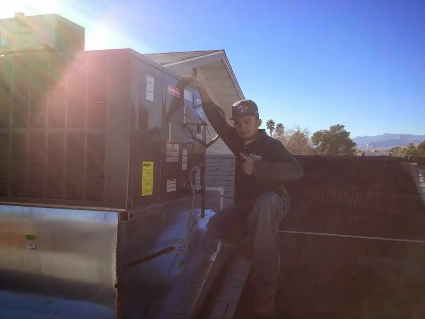 HVAC technician performing Air Duct Cleaning on a rooftop unit in Sweetwater